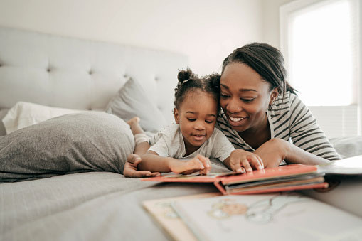 African American mom and daughter reading