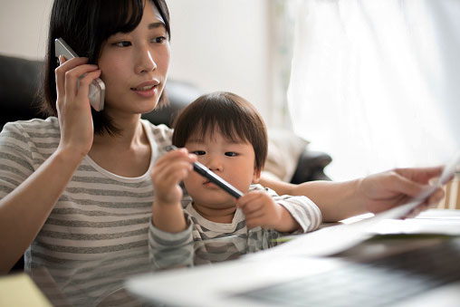 Madre y niño asiáticos en teléfono para beneficios