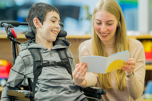 Boy in wheelchair with care provider