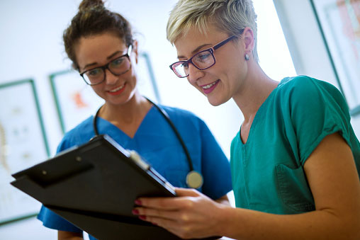 Two female nurses looking over chart
