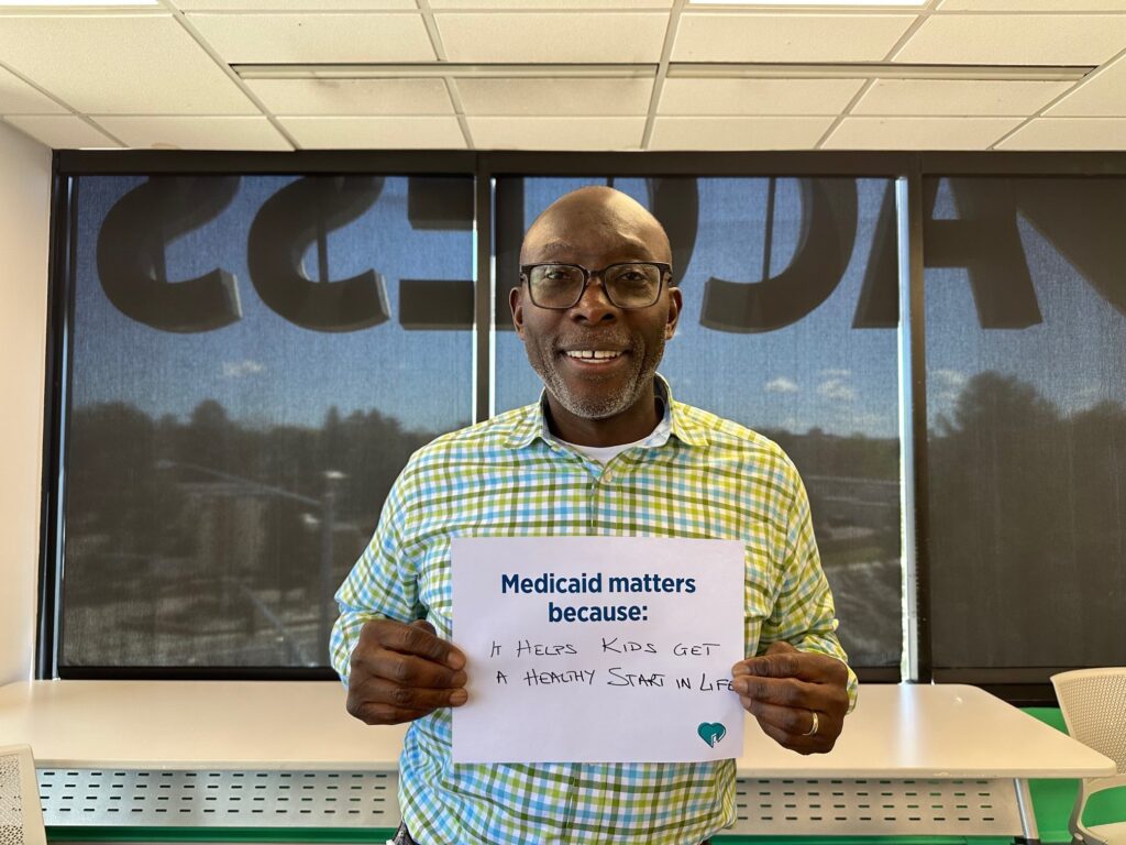 Man holding "Medicaid Matters Because..." sign
