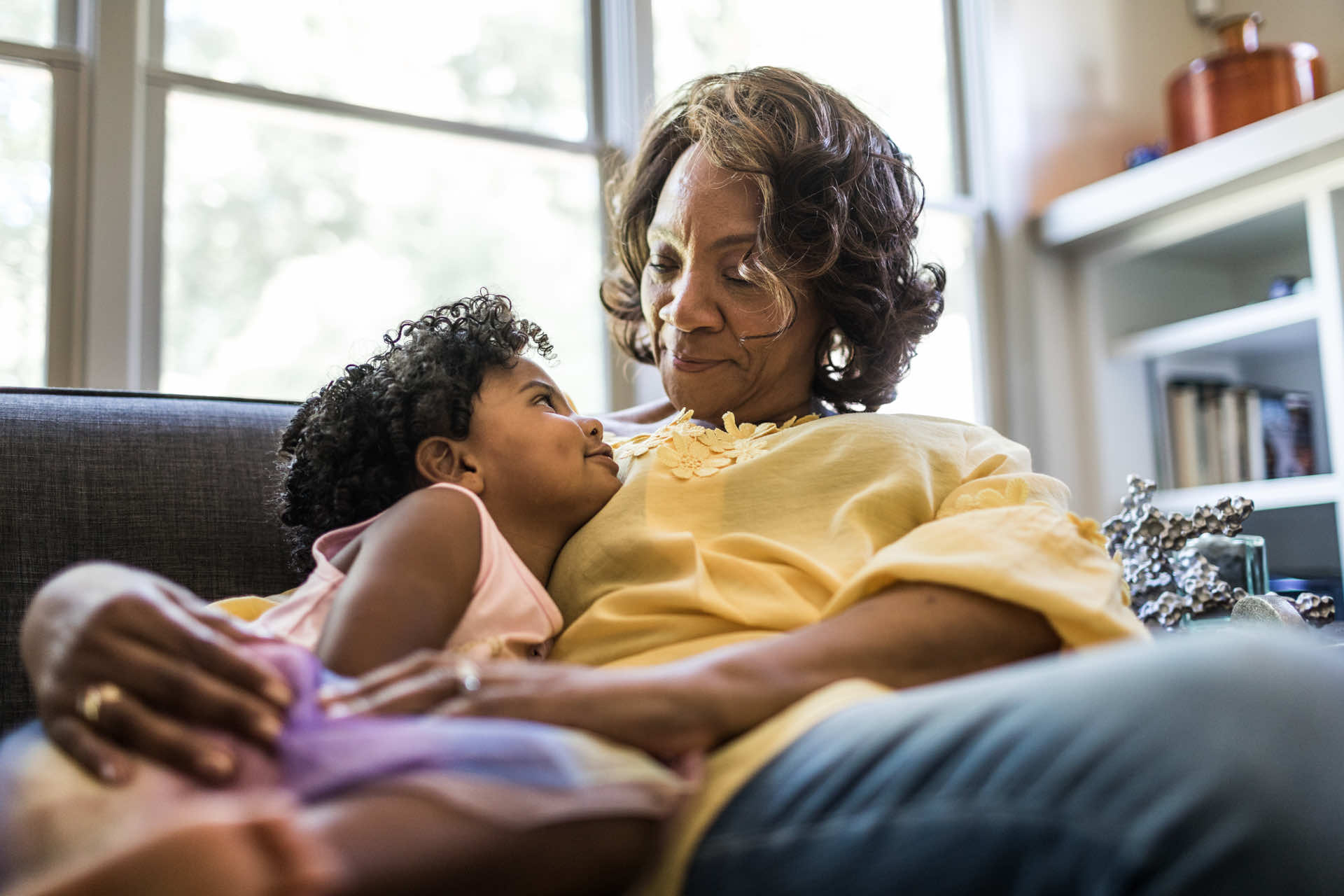 An older woman and a young girl sitting together on a couch