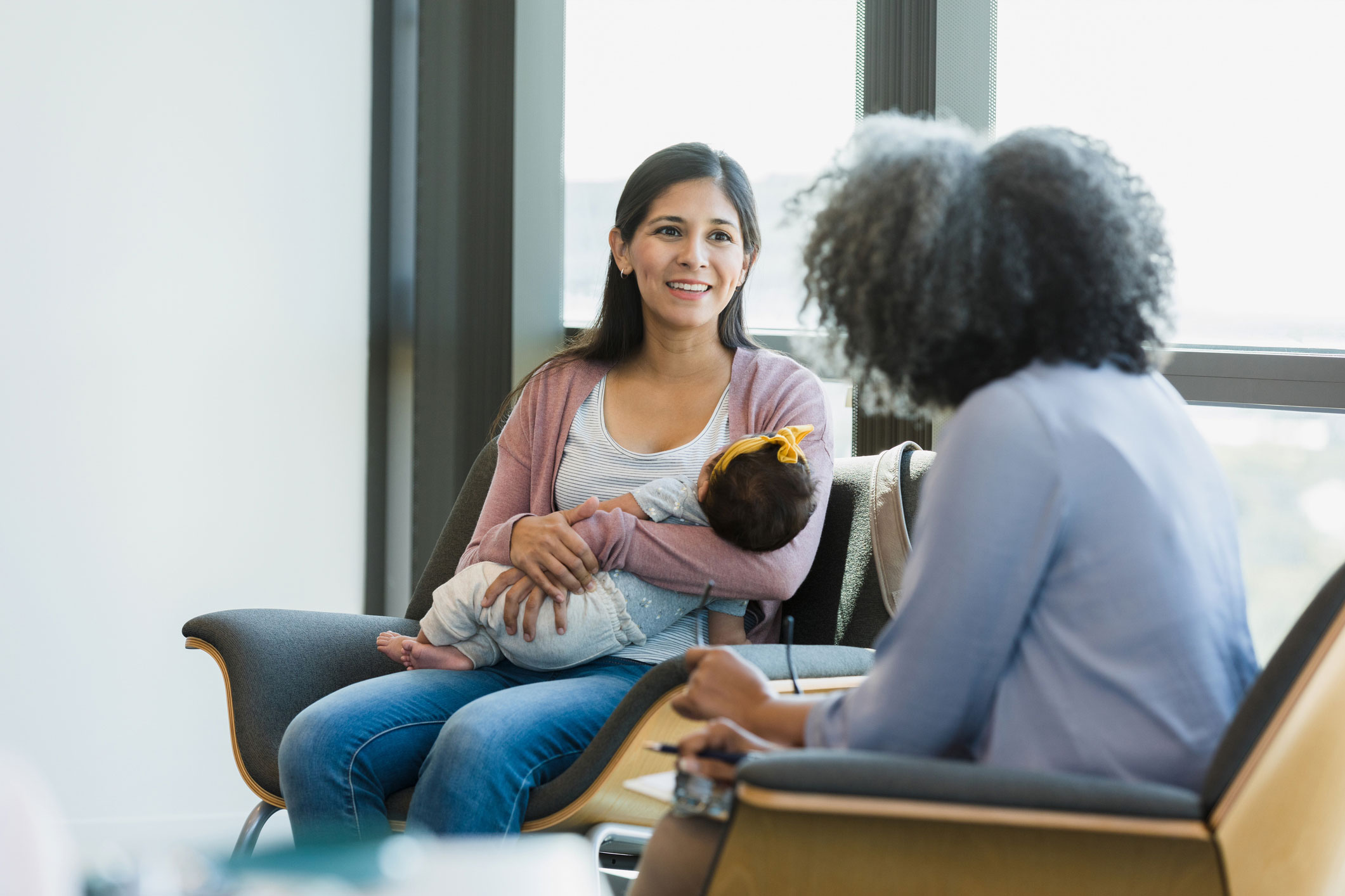 Woman holding a newborn at a doctor's appointment